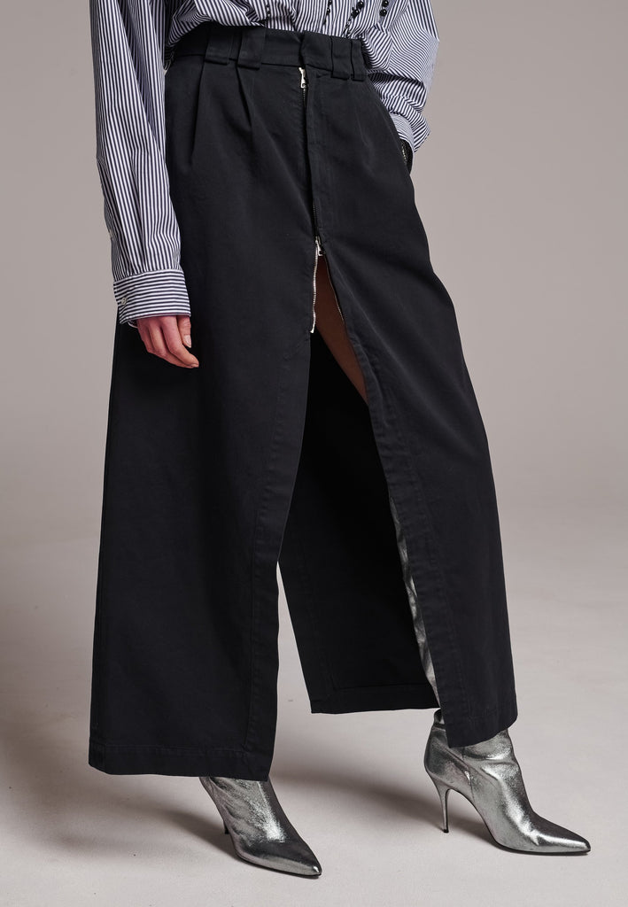 A deconstructed chino skirt featuring prominent front and back slits which create effortless movement within every step. Features pockets and big belt loops.