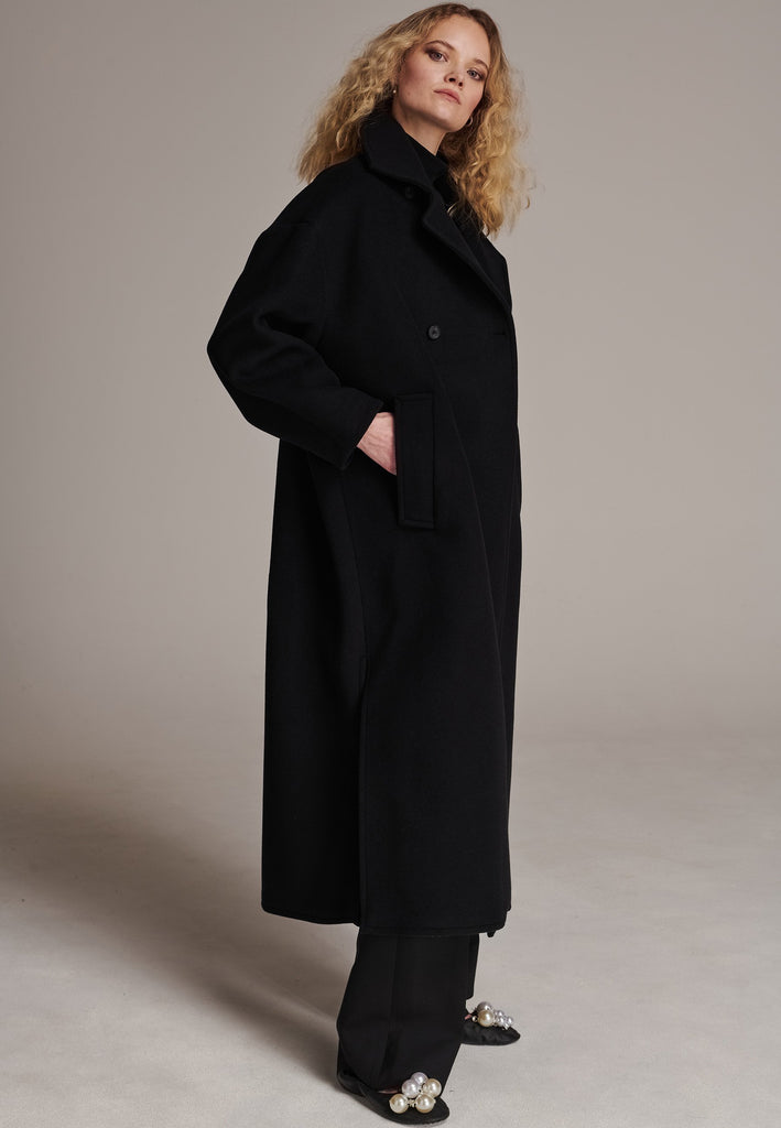 This long, oversized coat is crafted from a luxurious cashmere-wool blend, designed to keep you both warm and stylish. Don’t miss the interior pocket finished with our couture zipper, and the ‘We Should Kiss’ mantra inside, a reminder to embrace kindness. This coat offers a cool, sophisticated look, perfect for pairing with everything from evening dresses to denim, making it a versatile statement piece you’ll want to wear everywhere.