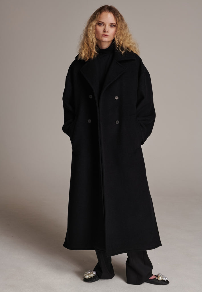 This long, oversized coat is crafted from a luxurious cashmere-wool blend, designed to keep you both warm and stylish. Don’t miss the interior pocket finished with our couture zipper, and the ‘We Should Kiss’ mantra inside, a reminder to embrace kindness. This coat offers a cool, sophisticated look, perfect for pairing with everything from evening dresses to denim, making it a versatile statement piece you’ll want to wear everywhere.