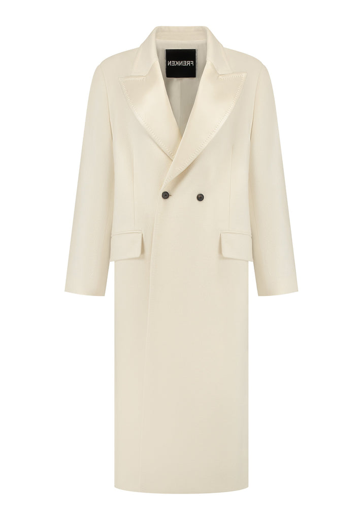 An effortless long coat to slip over any outfit. Detailed by sharp shoulder pads, double-breast fittin and square hole horn buttons. The ankle-grazing length emphasizes the loose fit and the effortless cool over tailoring. FRENKEN makes dressing up every morning easier.