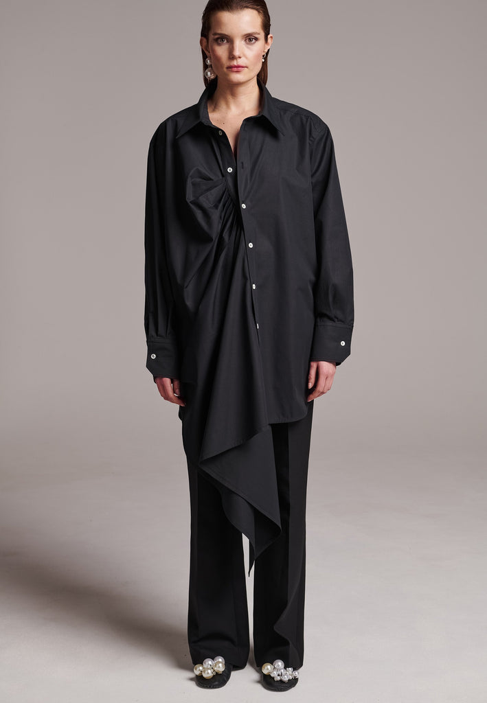 Oversized asymmetric shirt. Specially detailed with a long ruffle effect on one side. It has a button closure to adjust the neckline. 100% Cotton and with an oversized loose shape. Designed for a comfortable and unique fit. A timeless piece.