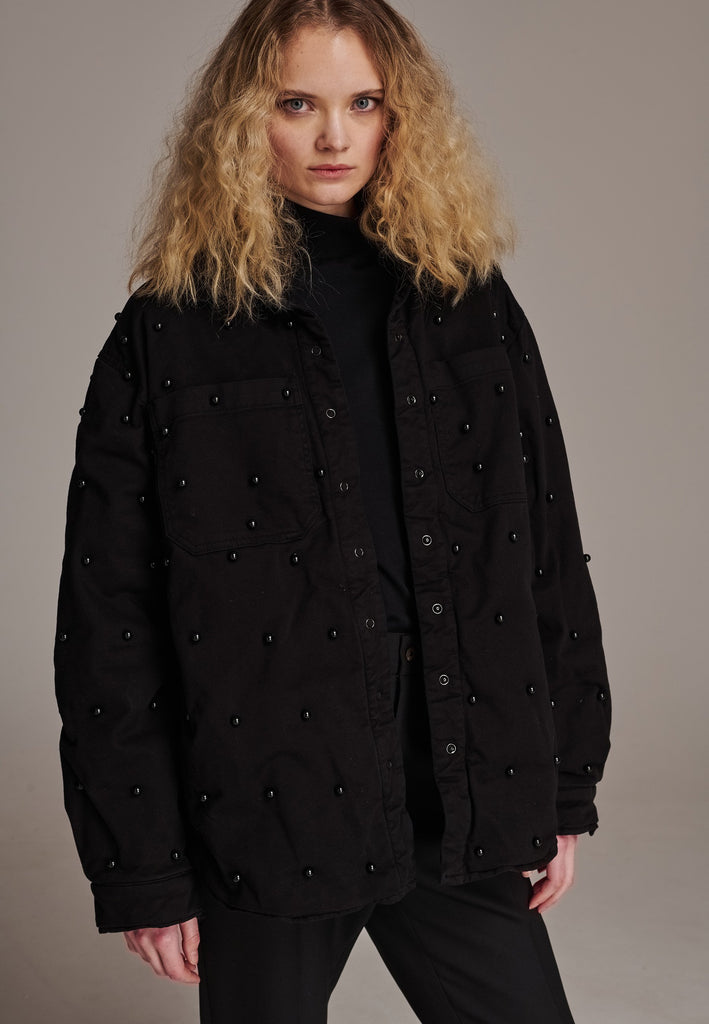 Shirt-effect coat adorned with faux black pearls, meticulously hand-applied. How would you wear it? Style it over a dress, pair it with a sleek tailored pant, or go for a bold look with oversized jeans. The possibilities are endless.