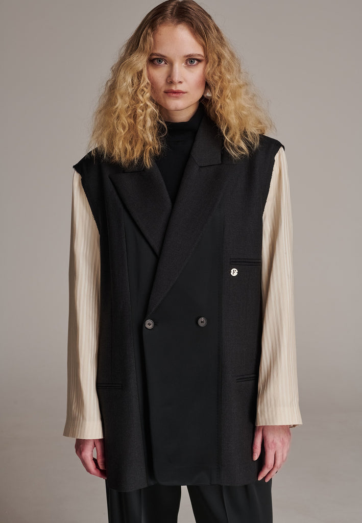 Perfectly tailored with a contemporary twist, this oversized blazer features unique inside-out details. The raw edge seam around the shoulder, where the tonal striped sleeve is set in, showcases its deconstructed design. Referencing the lining, the sleeve and welt pocket holds a charming Frenken lucky coin. A rounded insert at the back shoulder and refined darts enhance the sophisticated silhouette. Broad, soft shoulders, double-breasted horn buttons, and a fully satin-lined interior complete this standout 