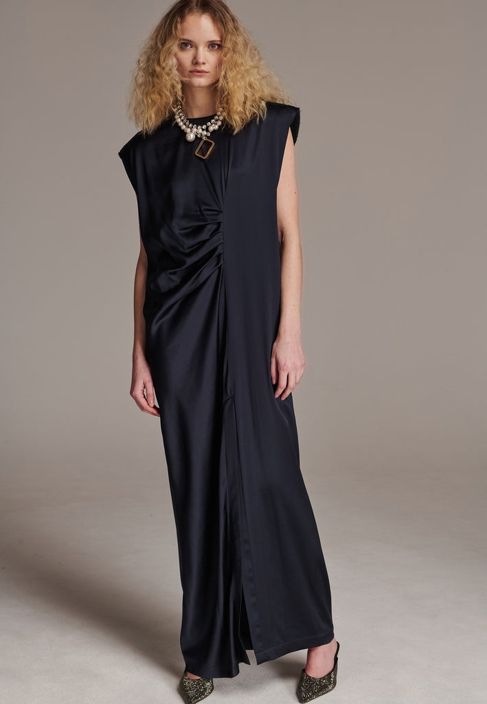 FRENKEN'S comfortable stretch-satin maxi dress is draped in a way that feels equally effortless and elegant. Raw-cut edge at the dramatically wide shoulders for a strong silhouette. Particularly long in length. Thoughtfully designed with gathered detailing, it offers a flattering fit that subtly conceals the midsection. Continue the leg-lengthening illusion of the glamorous front high-slit with point-toe pumps. Designed for a draped silhouette, cut to be worn very loose and very oversized. This dress ensure