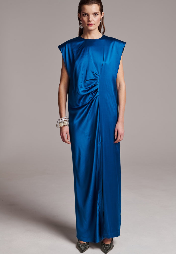 FRENKEN'S comfortable stretch-satin maxi dress is draped in a way that feels equally effortless and elegant. Raw-cut edge at the dramatically wide shoulders for a strong silhouette. Particularly long in length. Thoughtfully designed with gathered detailing, it offers a flattering fit that subtly conceals the midsection. Continue the leg-lengthening illusion of the glamorous front high-slit with point-toe pumps. Designed for a draped silhouette, cut to be worn very loose and very oversized. This dress ensure