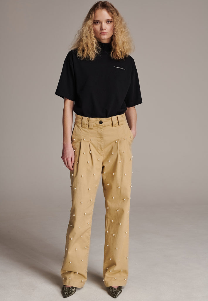 Mid-waist boyish trousers. With pearls at the front, detailed with pockets and big belt loops. Designed by Frenken, this piece offers a slightly oversized fit that combines effortless style with understated fashion.