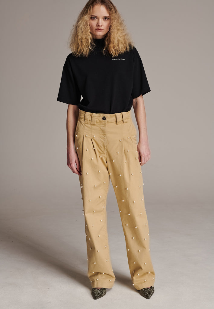 Mid-waist boyish trousers. With pearls at the front, detailed with pockets and big belt loops. Designed by Frenken, this piece offers a slightly oversized fit that combines effortless style with understated fashion.