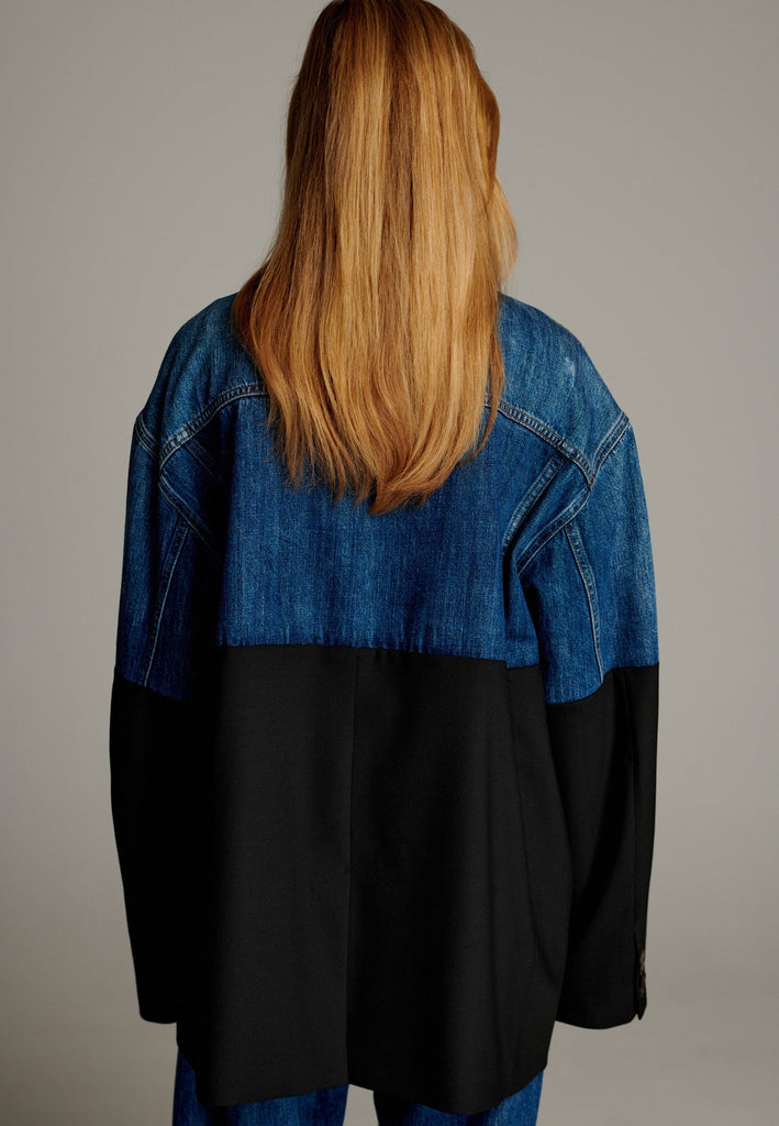 This unique jacket combines two timeless styles into one bold statement piece. The upper half showcases classic blue denim with a casual, relaxed vibe, while the bottom half transitions seamlessly into a sleek black blazer for a polished, tailored look. The contrast between the two halves creates a striking visual effect, blending casual and formal elements effortlessly.