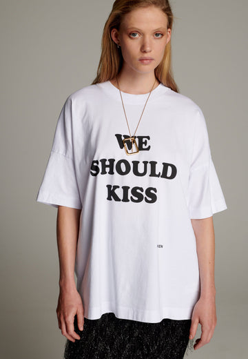 What better way to elevate your everyday look than with this t-shirt. This boxy fit tee is printed with the playful "We Should Kiss" slogan, adding a fun, flirty touch to your outfit. Designed with relaxed drop shoulders, a straight hem, and a classic crew neckline, it offers both style and comfort.