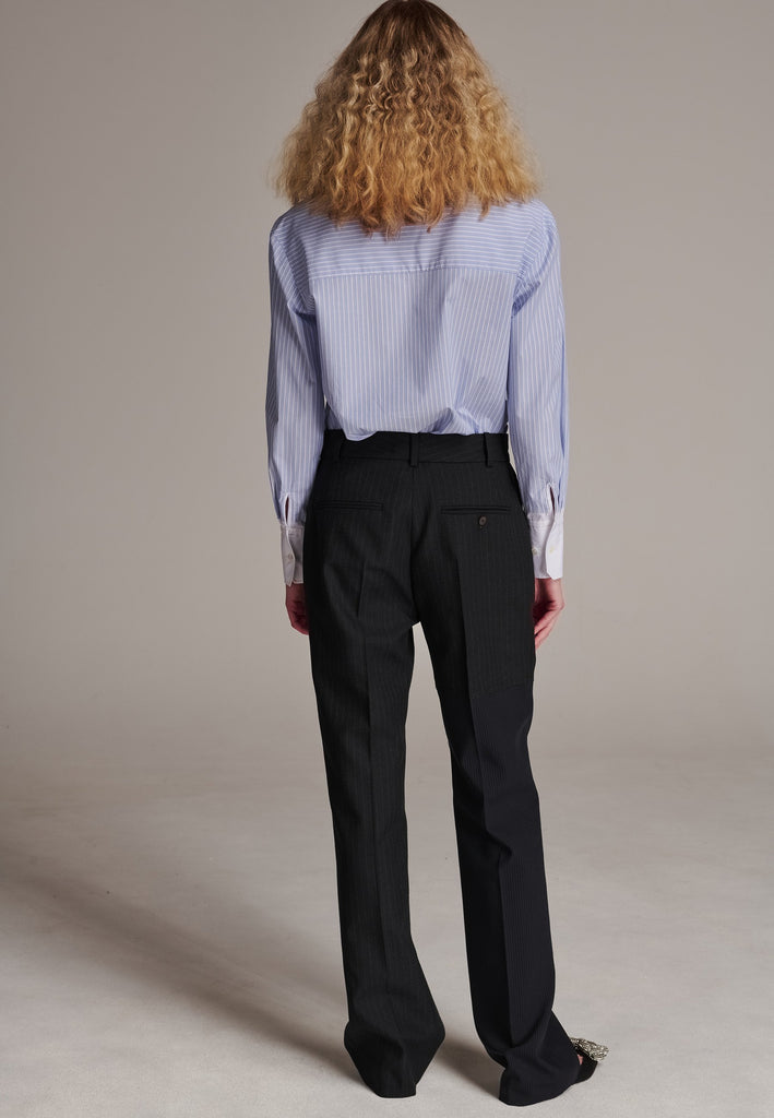 This straight-fitted pant, inspired by a masculine fit, features a subtle surprise: one leg crafted from a different fabric, noticeable only to the discerning eye. These trousers elongate the legs and can be worn as part of a sharp, complete suit. Style them casually with a T-shirt or an oversized shirt with rolled-up sleeves and an open front for a more relaxed, effortless look.