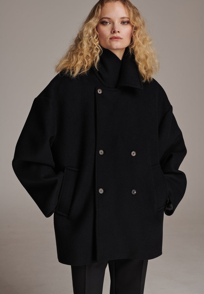 Beautifully designed and inspired by the classic men’s peacoat, this piece is tailored for an oversized fit that offers both comfort and warmth. Expertly tailored in Portugal from a soft, naturally insulating wool cashmere blend. Crafted to be worn loosely, it envelops you in cozy luxury while providing excellent protection against the cold. A must-have for those seeking both style and functionality in their outerwear. Layer it over everything from tailored trousers to casual denim for an instantly elevated