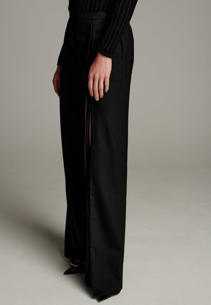 Made from a mix of polyester, wool, and elastane, they offer a soft, stretchy feel with a flattering drape. Designed with an elastic waistband, these pants ensure all-day comfort and a flexible fit. Featuring invisible zipper slits on both legs, they add a modern, stylish edge while allowing for ease of movement.