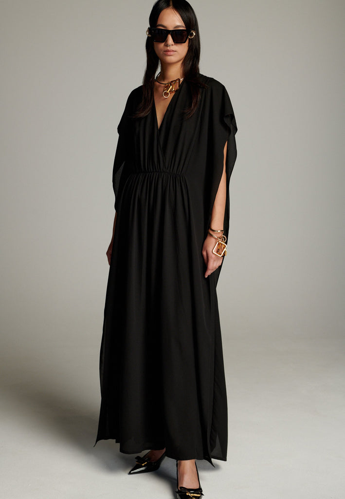 This dress features a flowing and elegant design in a black hue, crafted from lightweight silk georgette. The V-neckline and cinched waist create a flattering silhouette, while the loose, cape-like sleeves add a touch of modern sophistication. Perfect for both formal occasions and chic casual settings, it exudes timeless elegance and versatility.