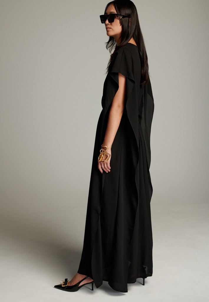 This dress features a flowing and elegant design in a black hue, crafted from lightweight silk georgette. The V-neckline and cinched waist create a flattering silhouette, while the loose, cape-like sleeves add a touch of modern sophistication. Perfect for both formal occasions and chic casual settings, it exudes timeless elegance and versatility.