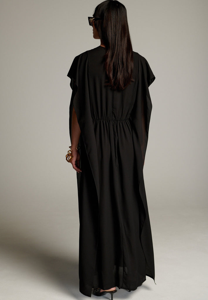 This dress features a flowing and elegant design in a black hue, crafted from lightweight silk georgette. The V-neckline and cinched waist create a flattering silhouette, while the loose, cape-like sleeves add a touch of modern sophistication. Perfect for both formal occasions and chic casual settings, it exudes timeless elegance and versatility.