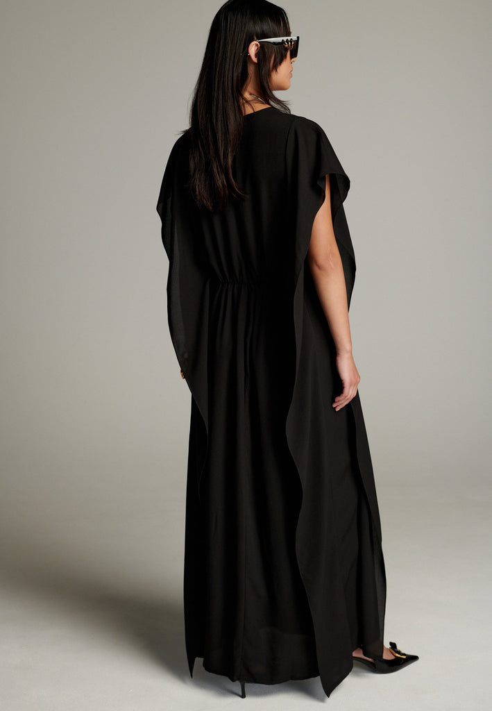 This dress features a flowing and elegant design in a black hue, crafted from lightweight silk georgette. The V-neckline and cinched waist create a flattering silhouette, while the loose, cape-like sleeves add a touch of modern sophistication. Perfect for both formal occasions and chic casual settings, it exudes timeless elegance and versatility.