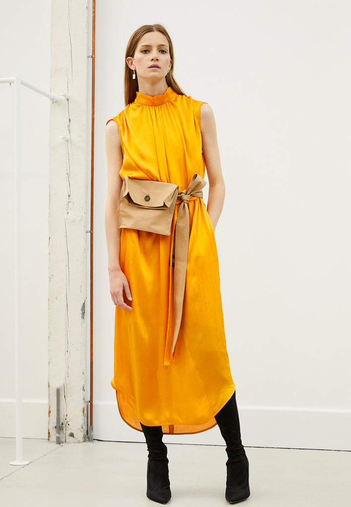 Conceal orange dress. Maxi dress in a wrinkle flowy satin light fabric. Wear it with the belt to create a waist or wear it without the belt and let the dress hang loose. Model wears a size 36.