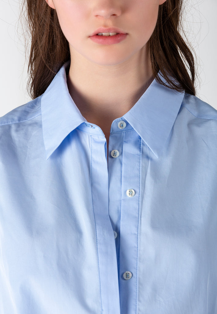 Double Placket | Shirt | Light Blue. Crispy poplin oversized shirt front panel smaller then back panel to give coverage in back and shape in front. Detailed with a double placket.