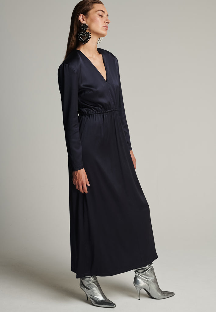 Shoulder-padded satin slim dress in navy. Features a v-neck, back and leg openings, and an elastic waistband. True to size.