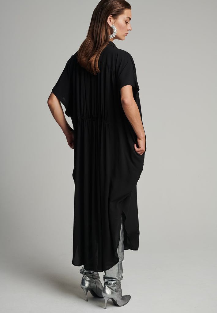 Silk midi dress in black. Features a short sleeve, front and back wrinkled effect, and an elastic waistband. Fits oversize.