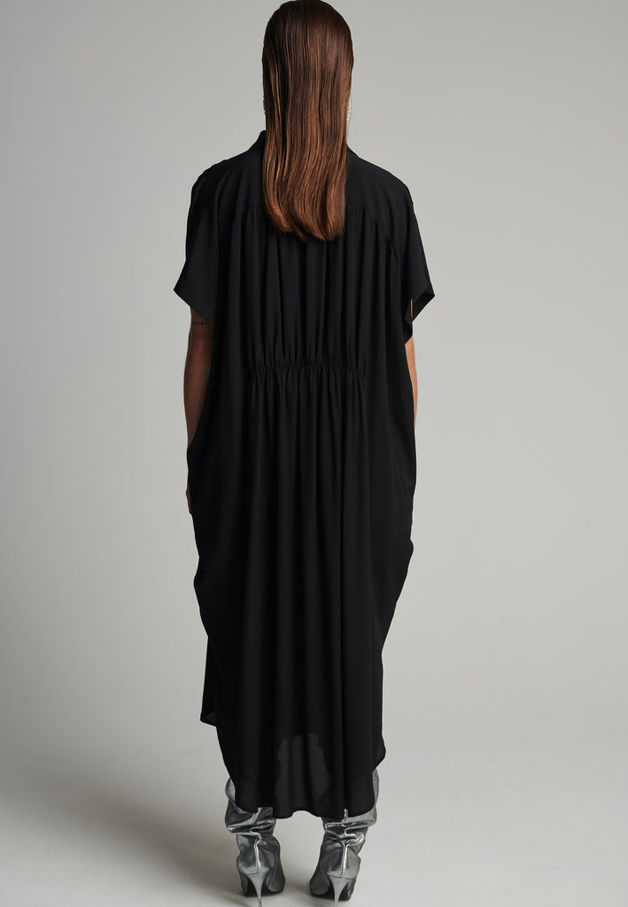 Silk midi dress in black. Features a short sleeve, front and back wrinkled effect, and an elastic waistband. Fits oversize.